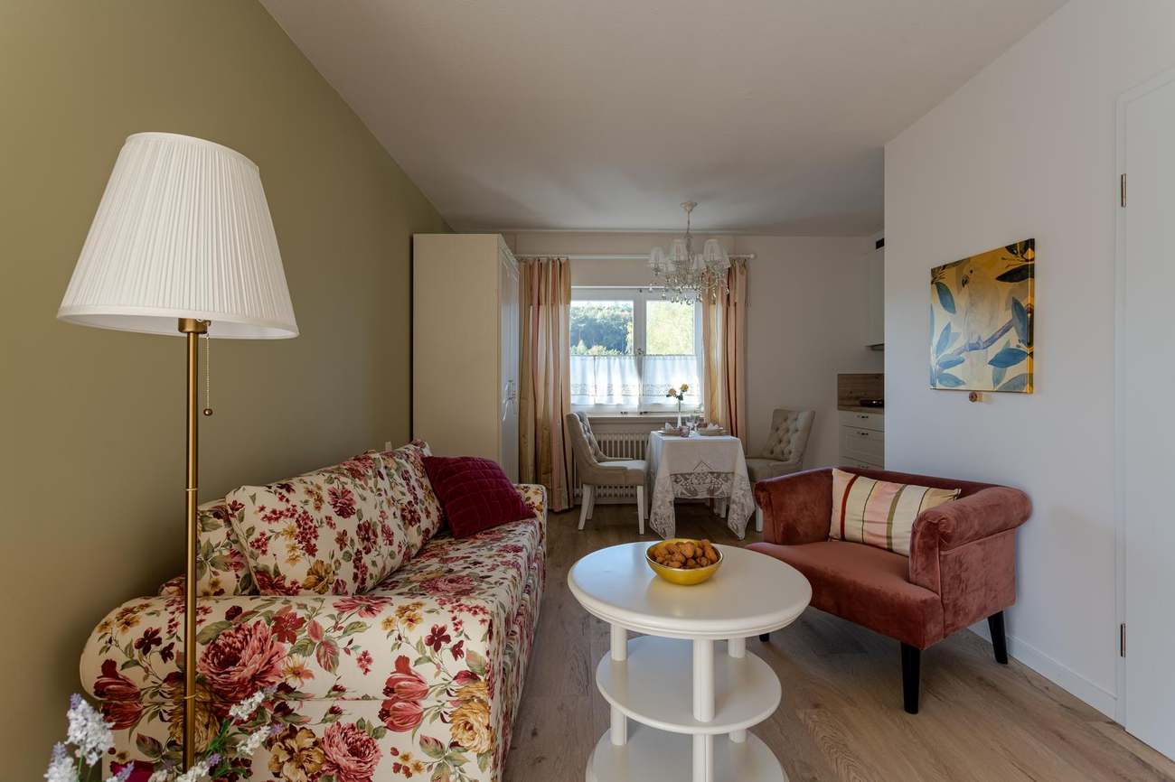 Wohnbereich mit Sofa, Sessel und Essplatz im Landhaus Appartement